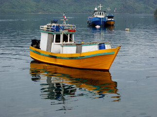 Yellow and white fishing barge waiting to go out again.