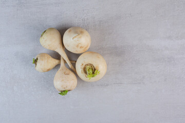 Raw white turnips on stone surface
