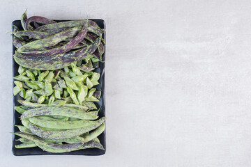 Organic green beans on black plate