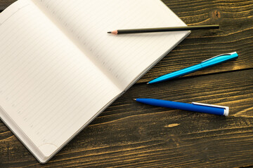 Diary for notes on a wooden table, pen and pencil