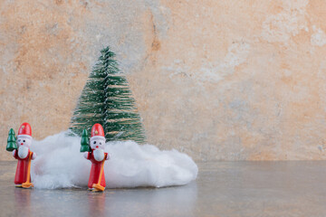 Two festive toys with Christmas tree and cotton wool