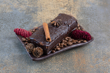 Chocolate roll with coffee beans and pinecones