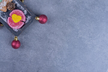 A dark board with cookie star and sugary jelly candies