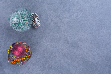 Chocolate donuts with Christmas ball and Christmas small tree