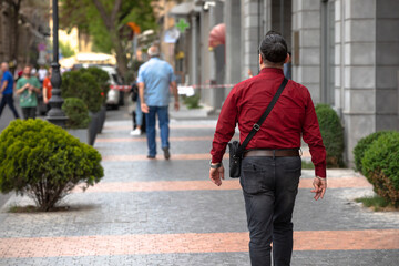 A man walks in the city on the sidewalk