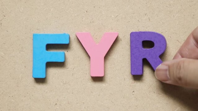 Man hold wood letter to complete english word FYR (abbreviation of for your reference)
