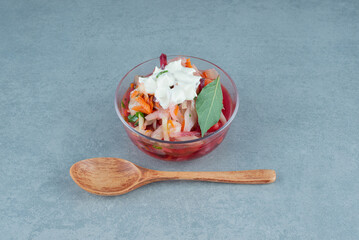 Chopped vegetables in glass bowl with spoon