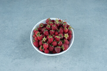 Fresh red raspberries in white bowl