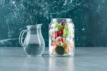 Chopped vegetables in glass jar with water