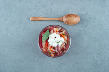 Chopped vegetables in glass bowl with spoon