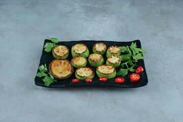 Grilled sliced zucchini on black plate