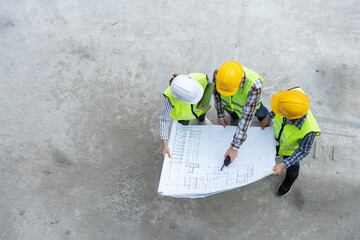 Top view of Asian engineer or Young Female Architect put on a helmet for safety and talk with a...