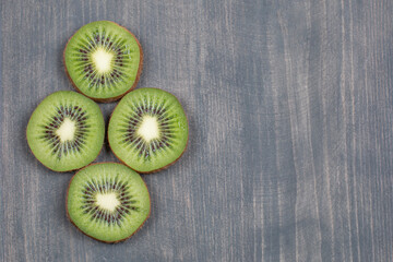 Ripe kiwi fruit slices on wooden surface