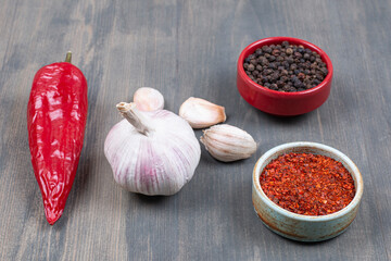 Pepper, garlic and spices on wooden surface