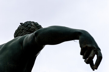 Low-angle view of a naked male sculpture against a sky in Le Petit Square Garden. Setif, Algeria.