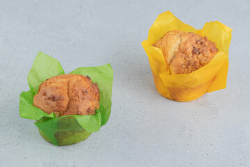 Two cupcakes displayed on marble background