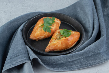 Small pide servings in a bowl nested on tablecloth on marble background