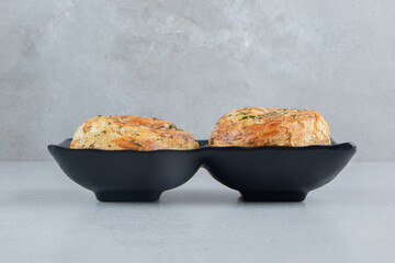 Two sour gogals on a black serving platter on marble background