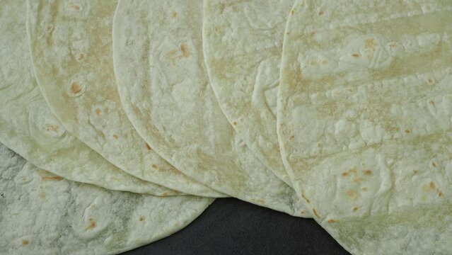 Corn tortillas on black background. Unleavened bread. Mexican tortillas