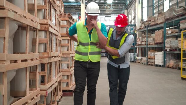 Caucasian chief co-worker carries worker to medical care clinic, health insurance for staff concept. Asian worker gets backache painful while lift heavy cardboard box to shelf in warehouse store
