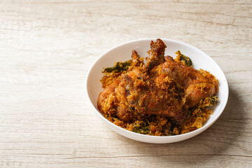 Ayam Goreng Padang. Traditional fried chicken with spice crumbs from Minangkabau, West Sumatra. served on white plate 
