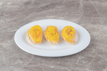Three small buns on a platter on marble background