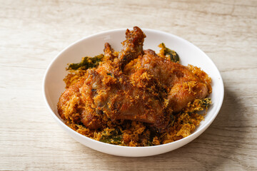 Ayam Goreng Padang. Traditional fried chicken with spice crumbs from Minangkabau, West Sumatra. served on white plate 