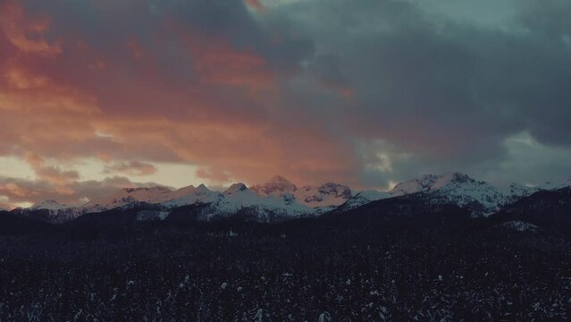 Amazing aerial shot of a beautiful winter mountain landscape of Julina Alps in the sunset, pink sky, and red clouds. Magical nature.