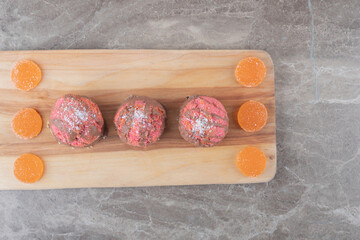 Arrangement of cookies and marmelades on a board on marble background