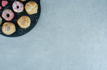 Dessert assortment on a serving board on marble background