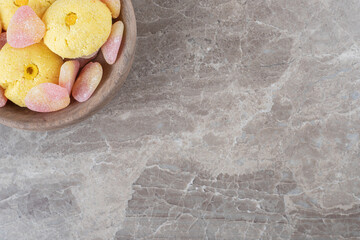 cookies and marmelades bundled in a small bowl on marble background