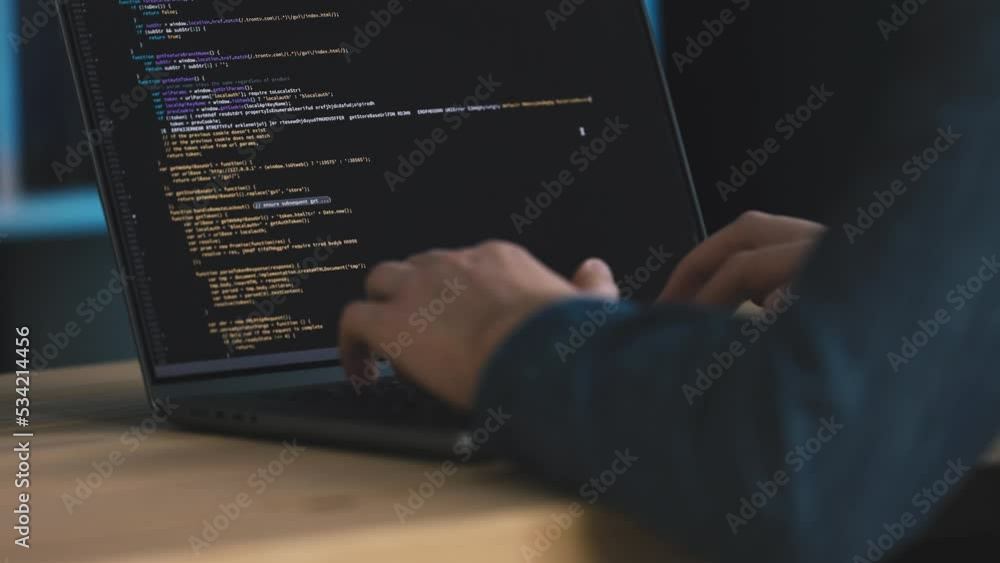 Poster man in denim shirt coding on laptop, screen full of code in real time