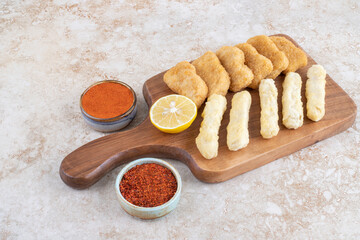 Chicken nuggets and cheese sticks with spices aside