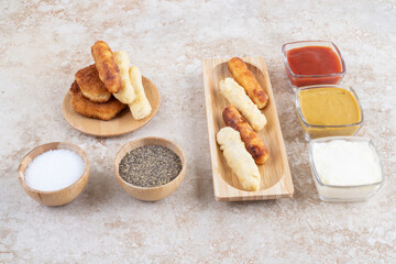 Grilled sausages and cheese sticks served with sauces