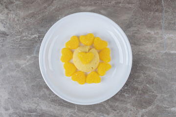 Heart marmelades surrounding a cookie on a platter on marble background