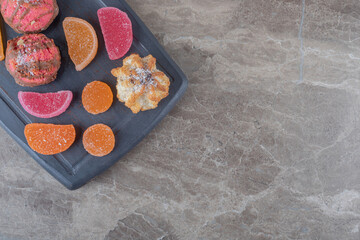 Navy board with marmelades and cookies on marble background