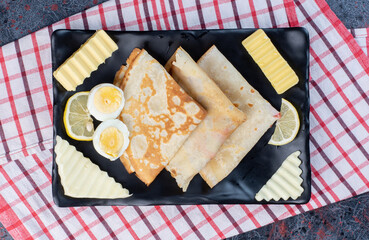 Crepes with egg, cheese and butter on a platter
