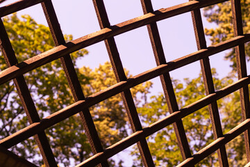 Wooden lattice on nature background. Fence of picket, seamless, horizontal on autumn foliage