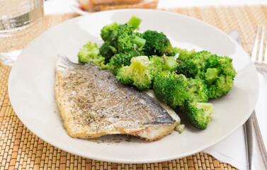 dish of fried dorado fish fillet with boiled broccoli