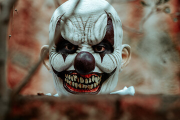evil clown stares at the observer in an old house