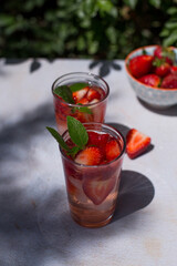 Soft drink or cocktail with strawberries and ice on a summer day. Concept of refreshing drinks.