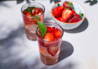 Soft drink or cocktail with strawberries and ice on a summer day. Concept of refreshing drinks.