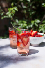 Soft drink or cocktail with strawberries and ice on a summer day. Concept of refreshing drinks.