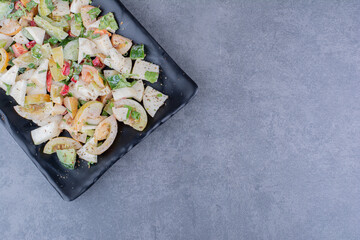 Salad with chopped herbs and vegetables on concrete background