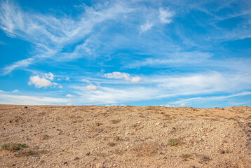 Endless azure sky with white clouds, sandy shore, beach. Calm inspiring view.