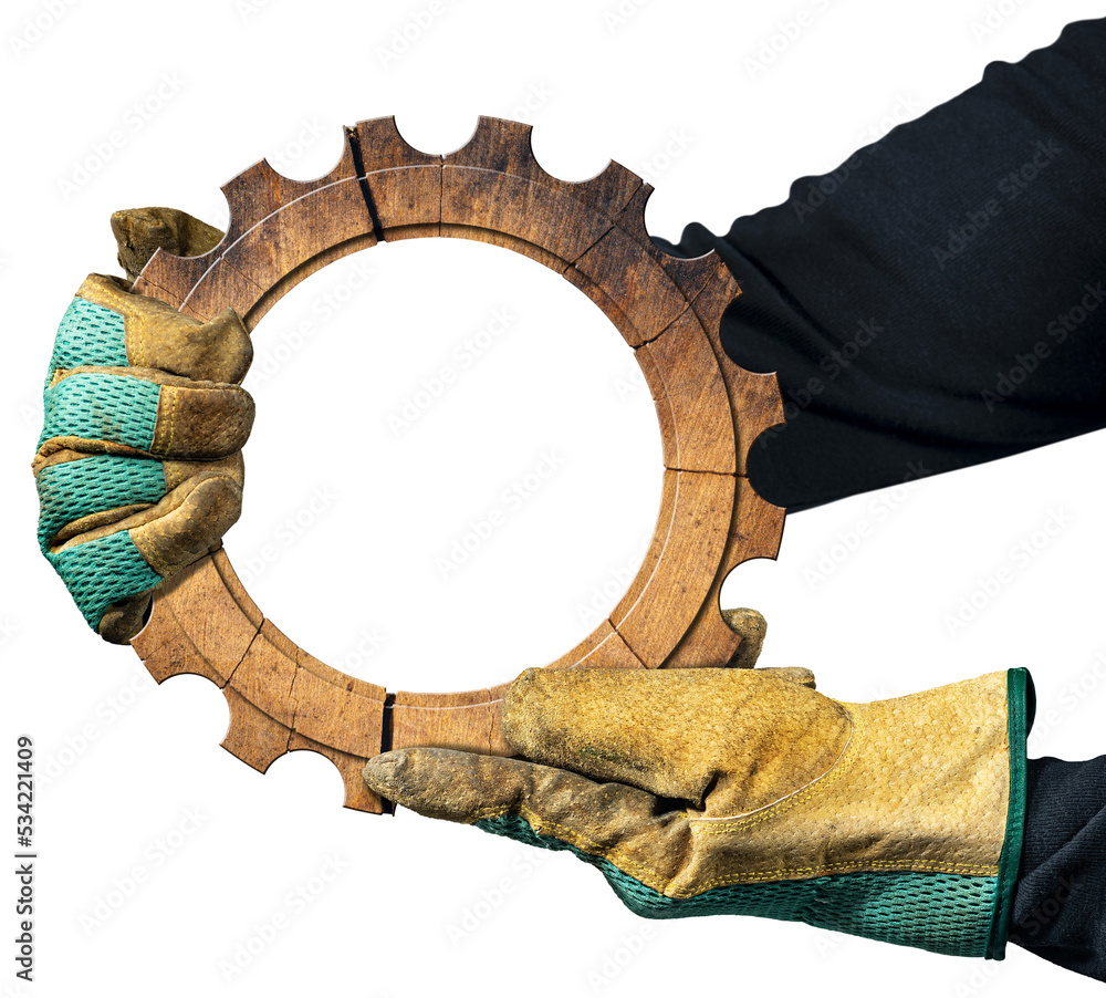 Poster manual worker with work gloves holding a wooden cogwheel with copy space inside. isolated on transpa