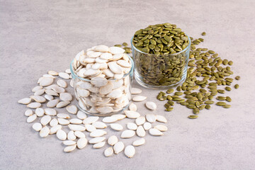 White and green pumpkin seeds on concrete background
