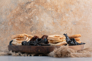 Dry fruits including apple slices, black sultana and jujube berries on concrete background