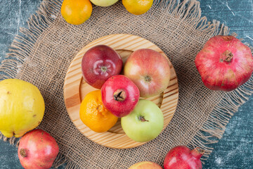 Seasonal fruits in a platter on blue background