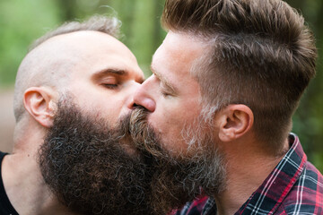 Long beard hipster gay couple passionately kissing. Male homosexual partners in late 30s,...